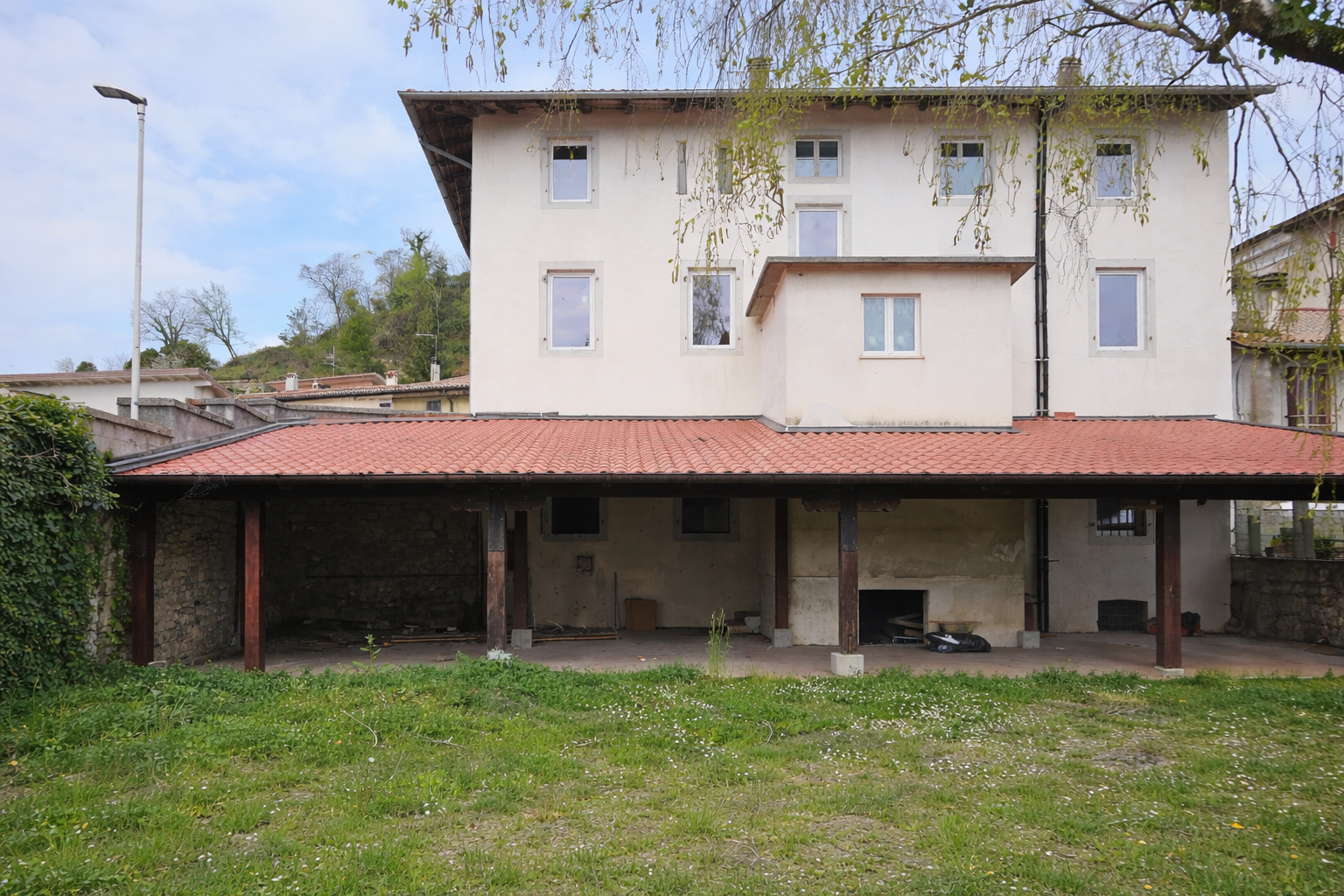 Vista del porticato e del giardino sul retro dell'edificio a Pinzano al Tagliamento